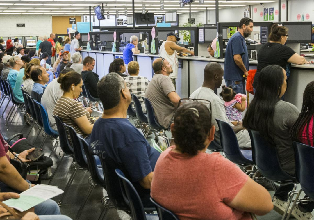 A group of people sitting in chairs at an airport.